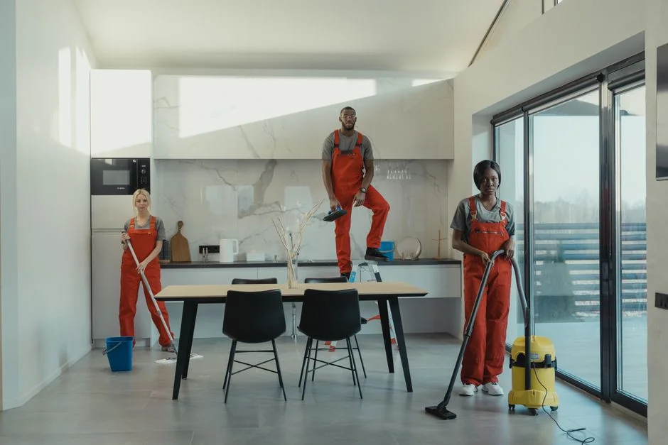 Individual in protective gear standing in a contemporary kitchen setting during the day.